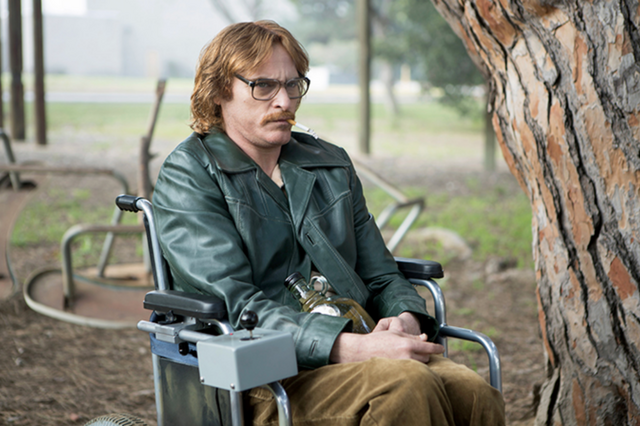 John is in a wheelchair, in the park. He has a cigarette in his mouth and a bottle of liquor on his lap. He seems very angry.