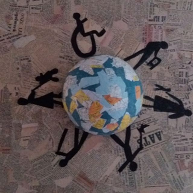 Op een ondergrond van krantenknipsels ligt een wereldbol van papier-maché. Rondom de wereldbol staan zwarte figuurtjes. Een van de figuurtjes zit in een rolstoel. Ze hebben allemaal verschillende voorwerpen vast.