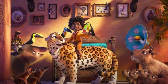 A dark-skinned, curly-haired little boy is sitting on a leopard in his living room, surrounded by other animals.
