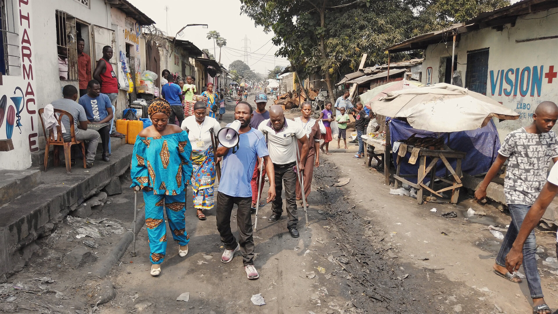 Still uit de film Downstream to Kinshasa. Enkele mensen met een handicap protesteren op straat